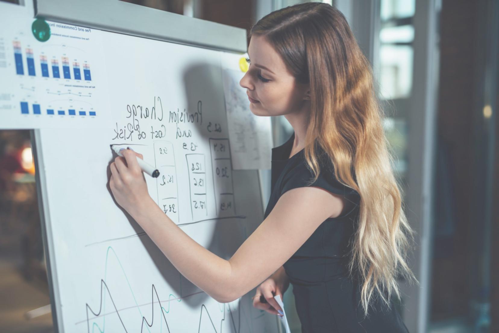 Person arbeitet konzentriert am Schreibtisch an Finanzplanung
